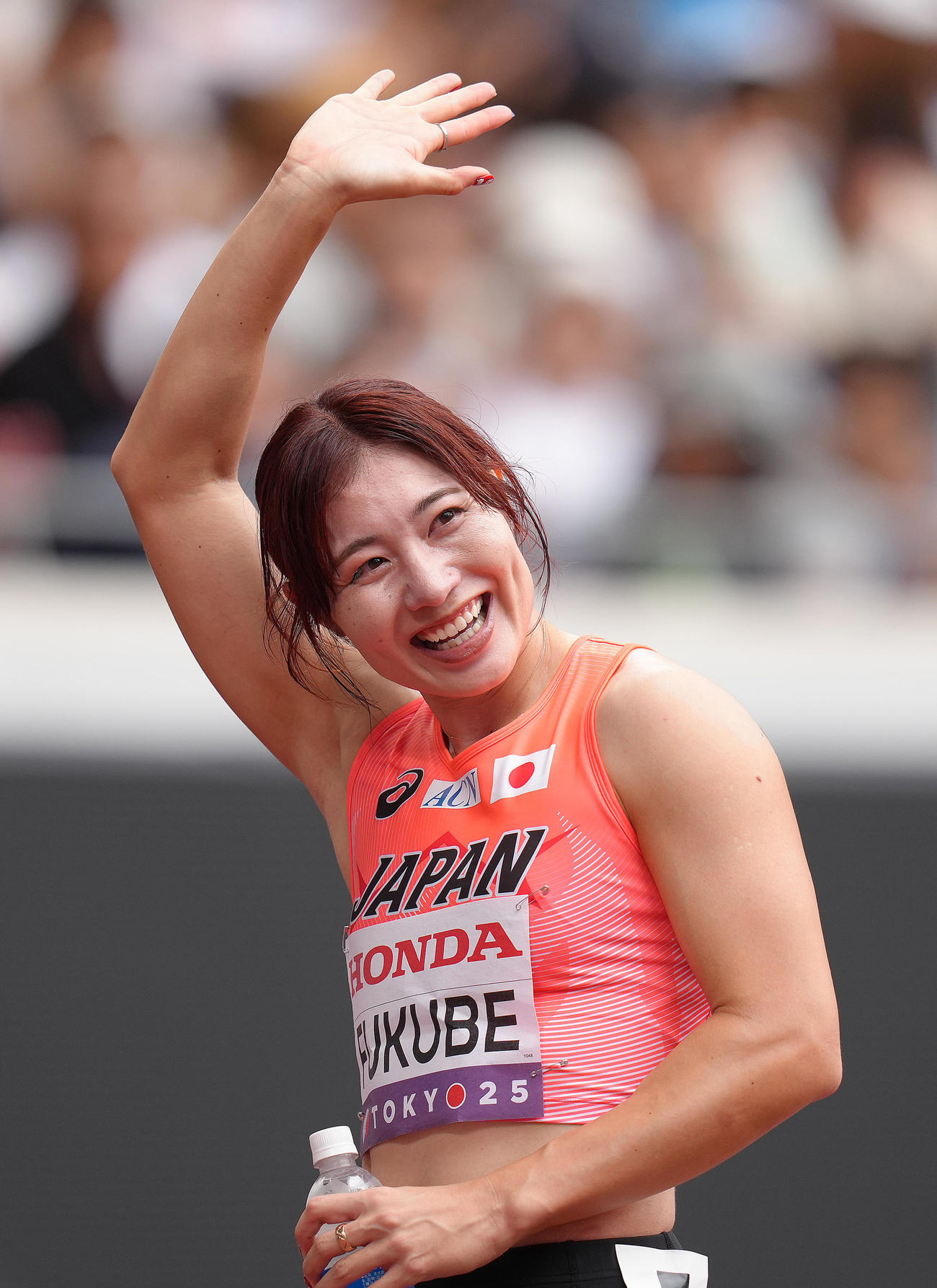 女子100メートル障害予選　レース後のインタビューを終え、スタンドに笑顔で手を振る福部（撮影・足立雅史）