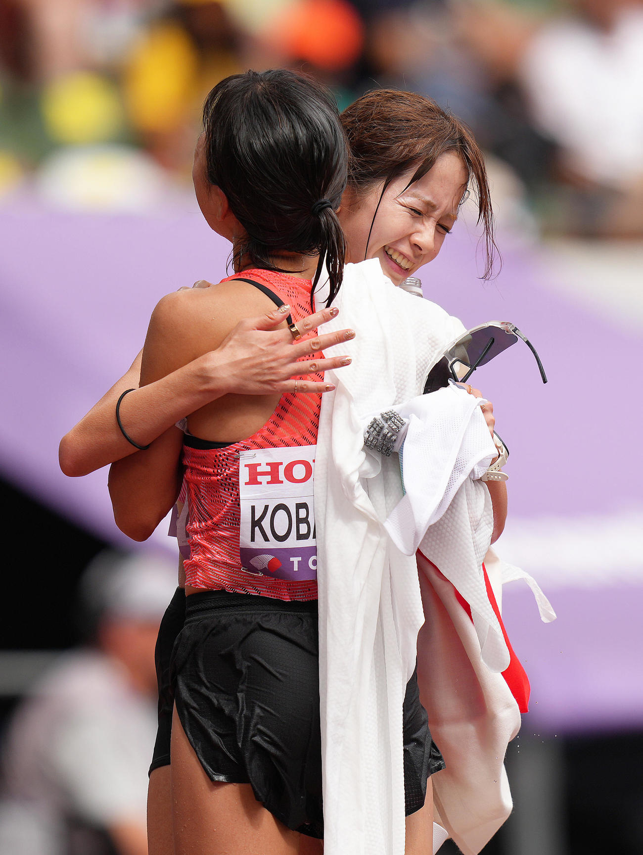 女子マラソン　13位でゴールした佐藤（後方）は小林と抱き合う（撮影・足立雅史）