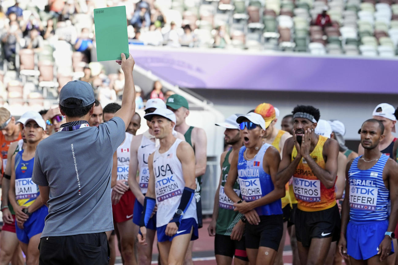 陸上世界選手権の男子マラソンで起きたフライングにグリーンカードが出され、驚く選手たち（AP）