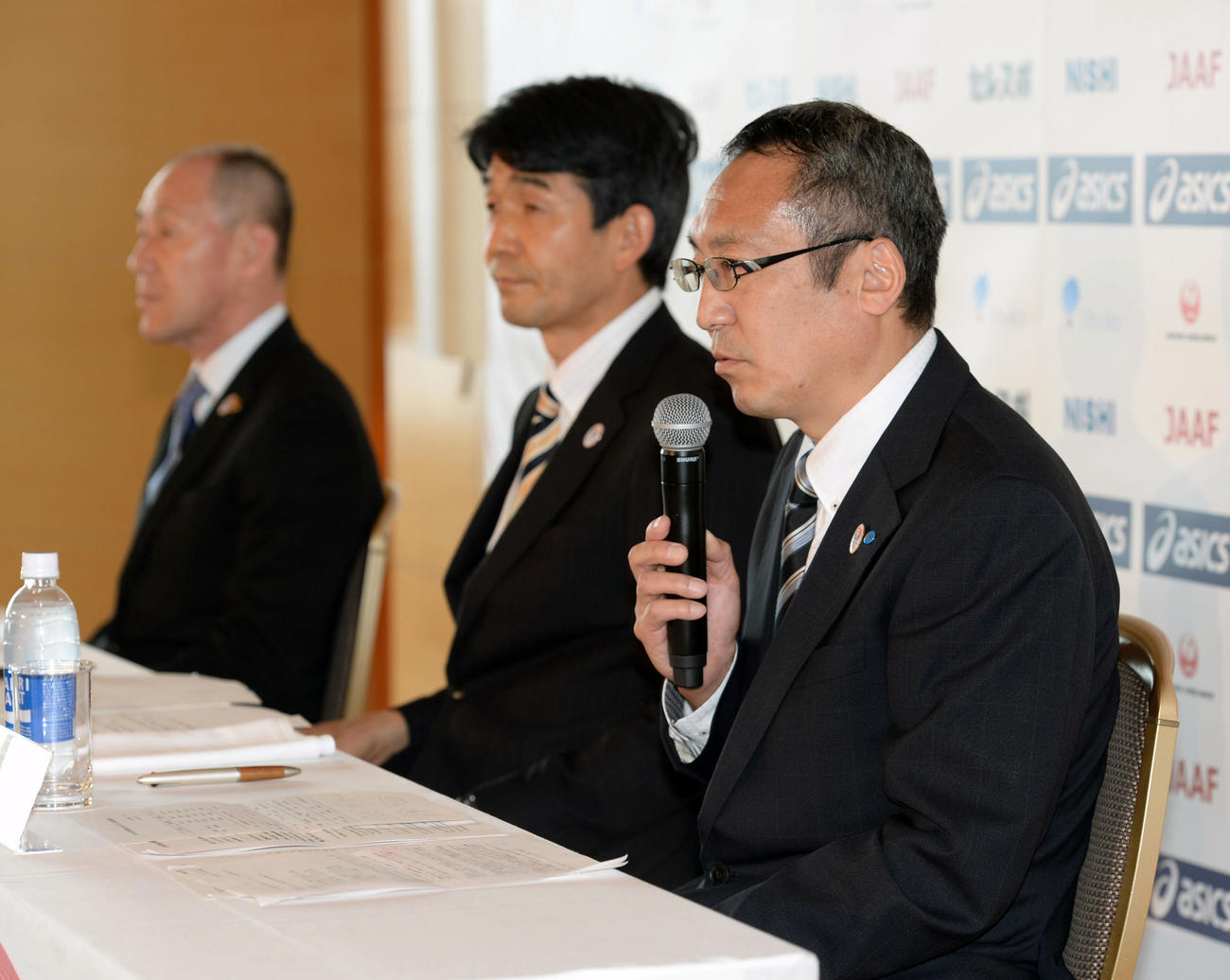 世界陸上マラソン代表発表会見で、質問に答える酒井強化副委員長。中央は尾縣専務理事、奥は原田理事・強化委員長