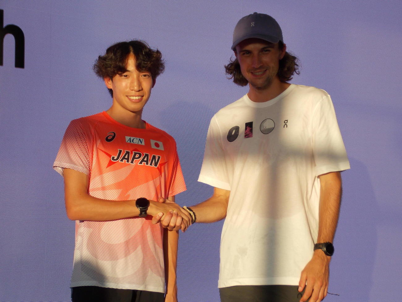 世界選手権男子3000メートル障害金メダルのジョーディー・ビーミッシュ（右）と8位の三浦龍司は一夜明け、トークショーで握手する（撮影・松本航）