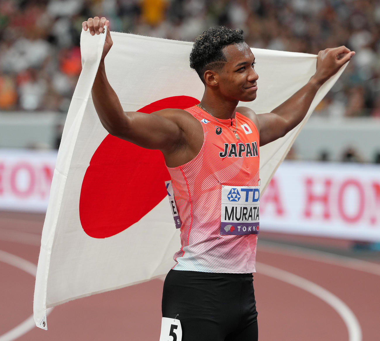 男子110メートル障害決勝　5位入賞し日の丸を掲げる村竹（撮影・足立雅史）