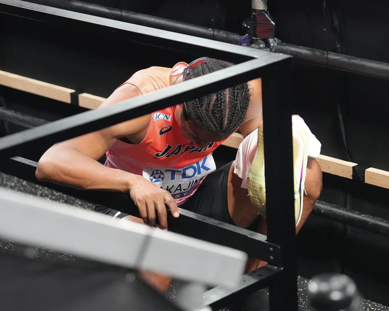 男子400メートル決勝　6位入賞の中島はミックスゾーンへの階段でしゃがみ込む（撮影・足立雅史）