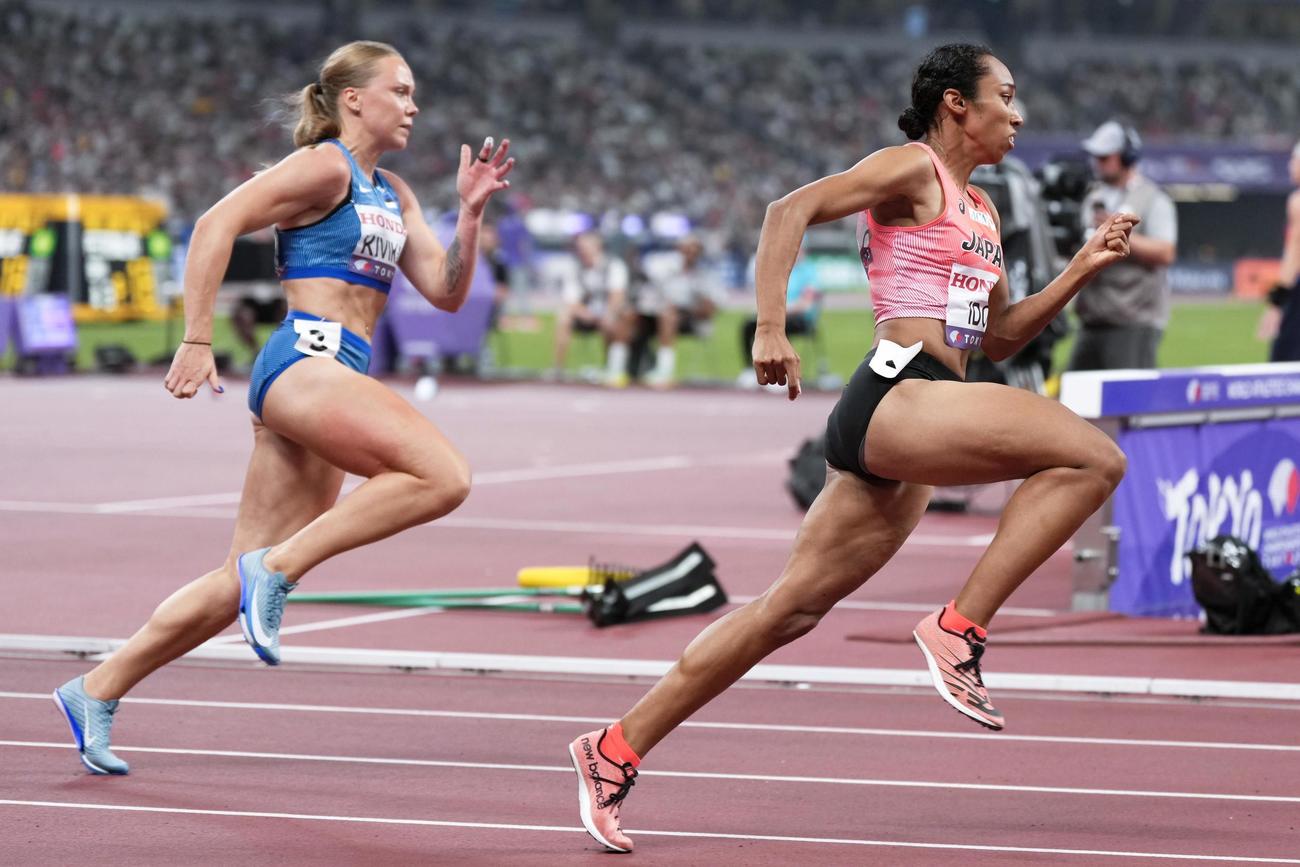 女子200メートル予選で力走する井戸アビゲイル風果（右）（共同）