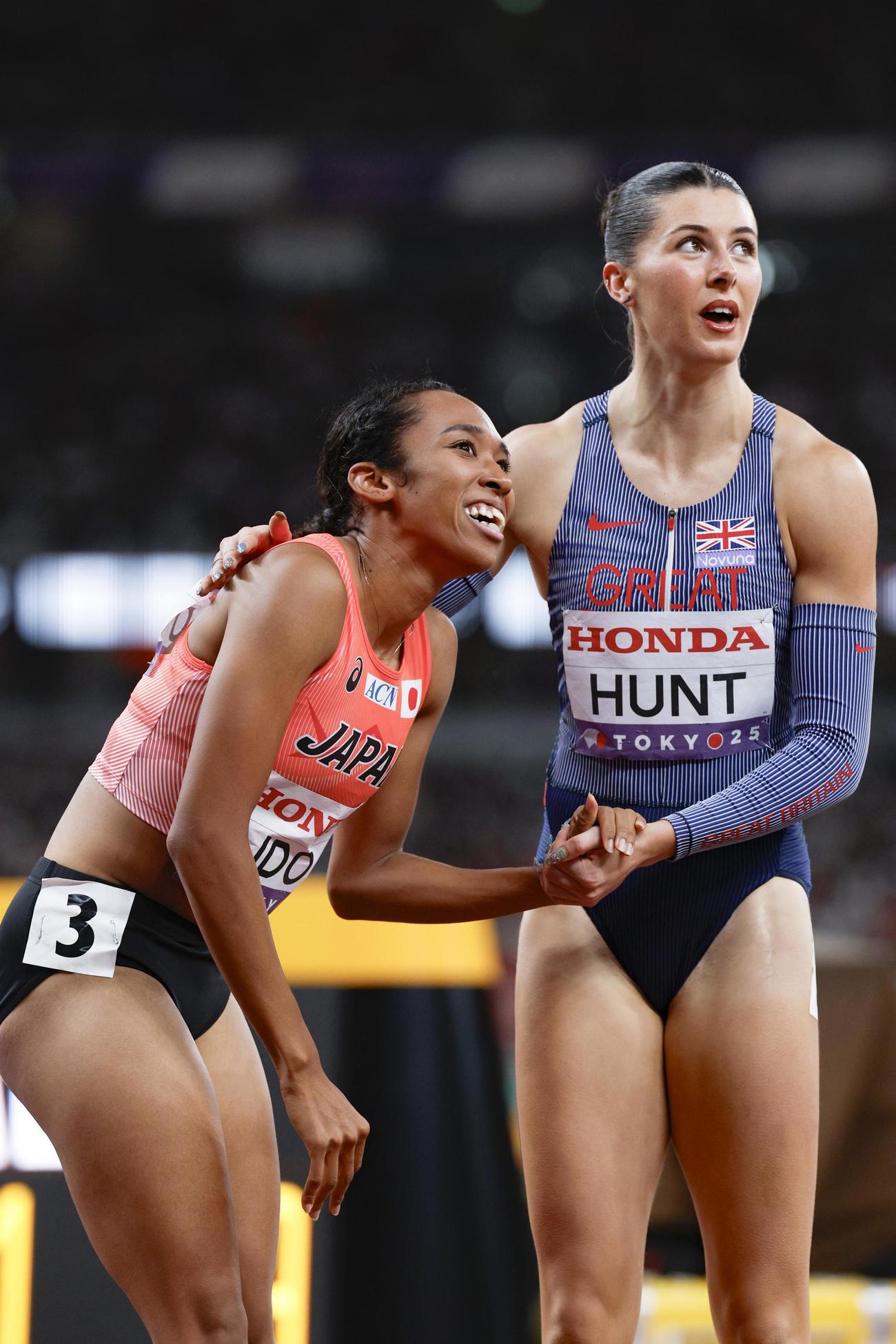女子200メートル準決勝　レースを終え、健闘をたたえ合う井戸アビゲイル風果（左）（共同）