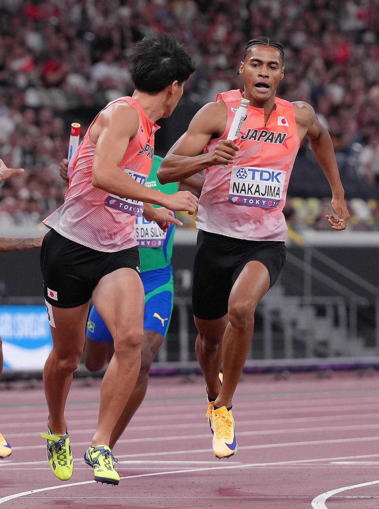 1600メートルリレー予選　バトンリレーに手間取る一走中島（右）と二走佐藤（撮影・足立雅史）