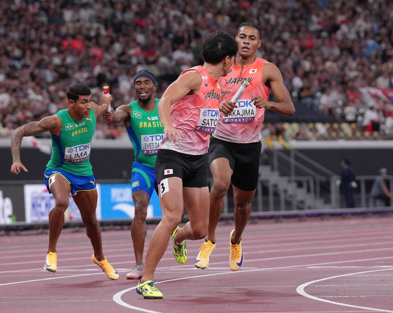 1600メートルリレー予選　バトンリレーに手間取る一走中島（右）と二走佐藤（撮影・足立雅史）