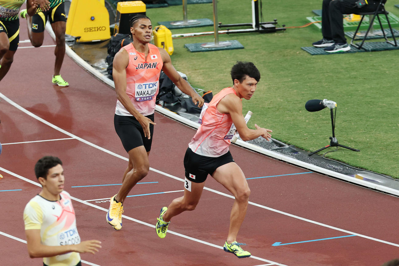 男子1600メートルリレー予選　1走中島（左）からバトンを受け取る2走佐藤（撮影・宮地輝）