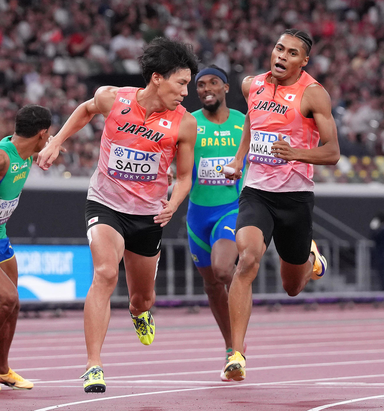 1600メートルリレー予選　バトンリレーに手間取る一走中島（右）と二走佐藤（撮影・足立雅史）