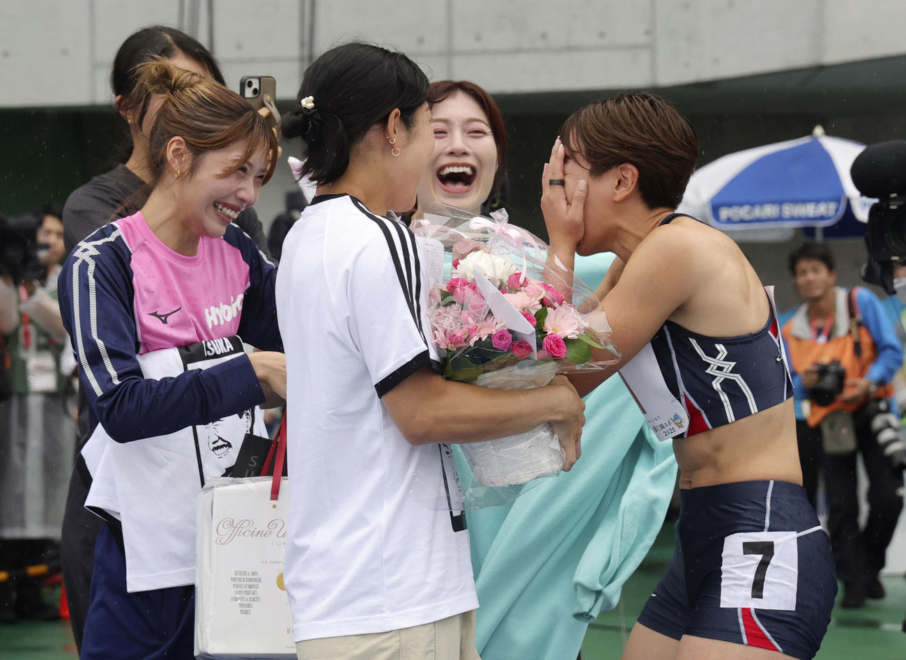 国民スポーツ大会の成年女子100メートル障害決勝を終え、サプライズで花束を贈られ顔を覆う北海道・寺田明日香＝平和堂HATOスタジアム（共同）