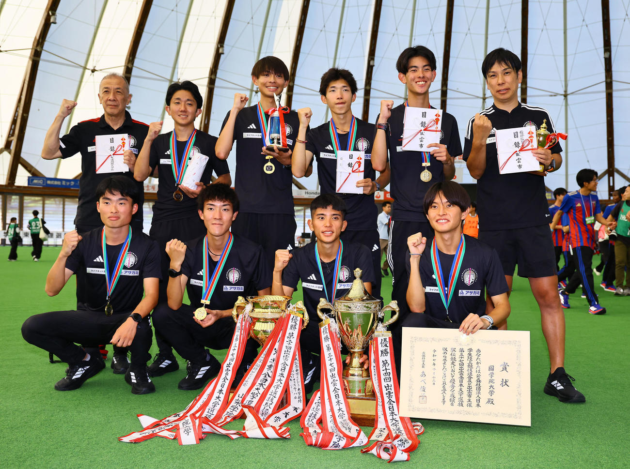 連覇を飾り記念写真に納まる前田康弘監督（右端）ら国学院大の選手ら（撮影・藤尾明華）