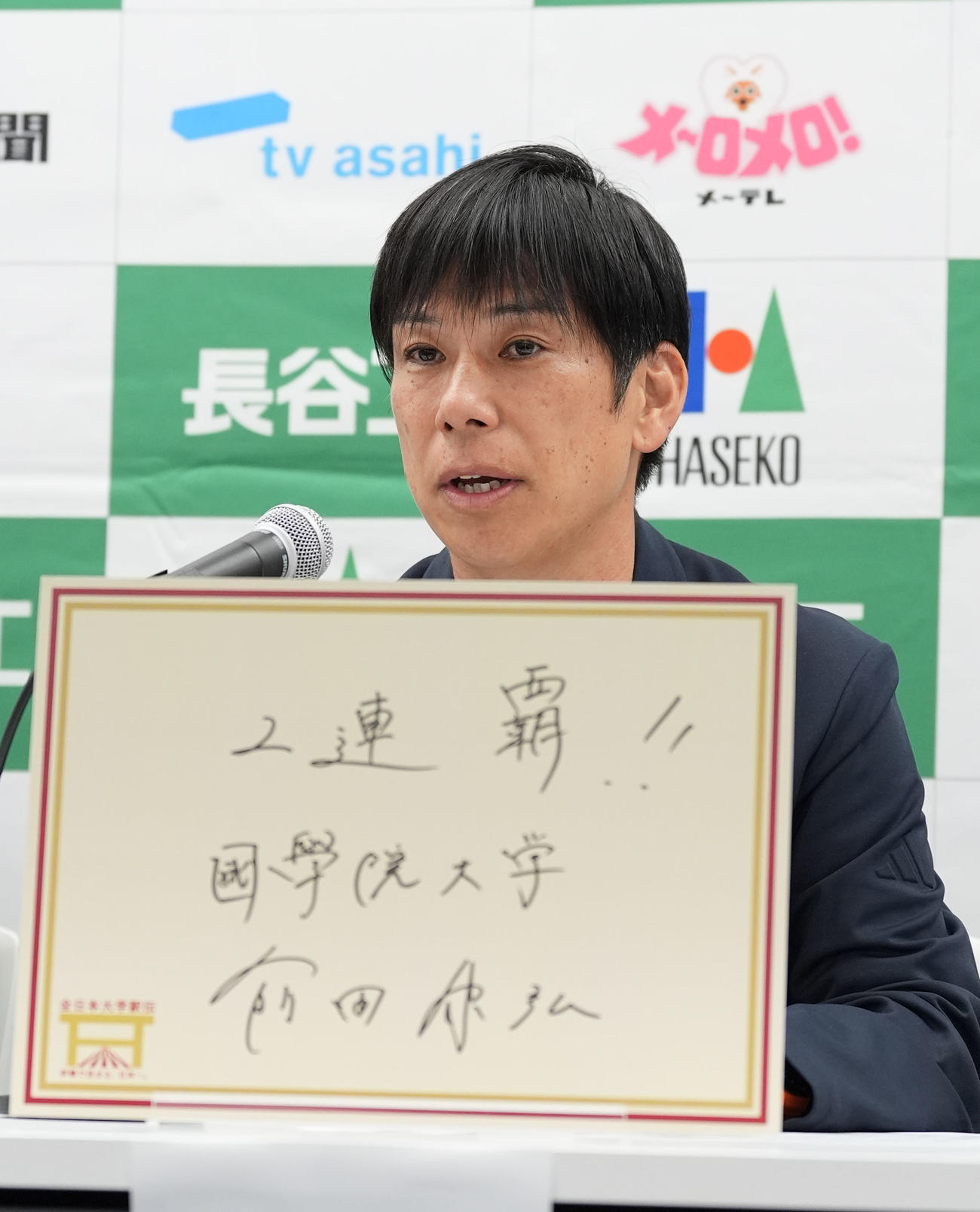 明日の大会のテーマをフリップに記す国学院大の前田監督（撮影・森本幸一）