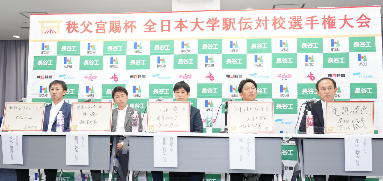 明日の大会のテーマをフリップに記す左から創価大の榎木監督、駒沢大の藤田監督、国学院大の前田監督、青山学院大の原監督、早稲田大の花田監督（撮影・森本幸一）