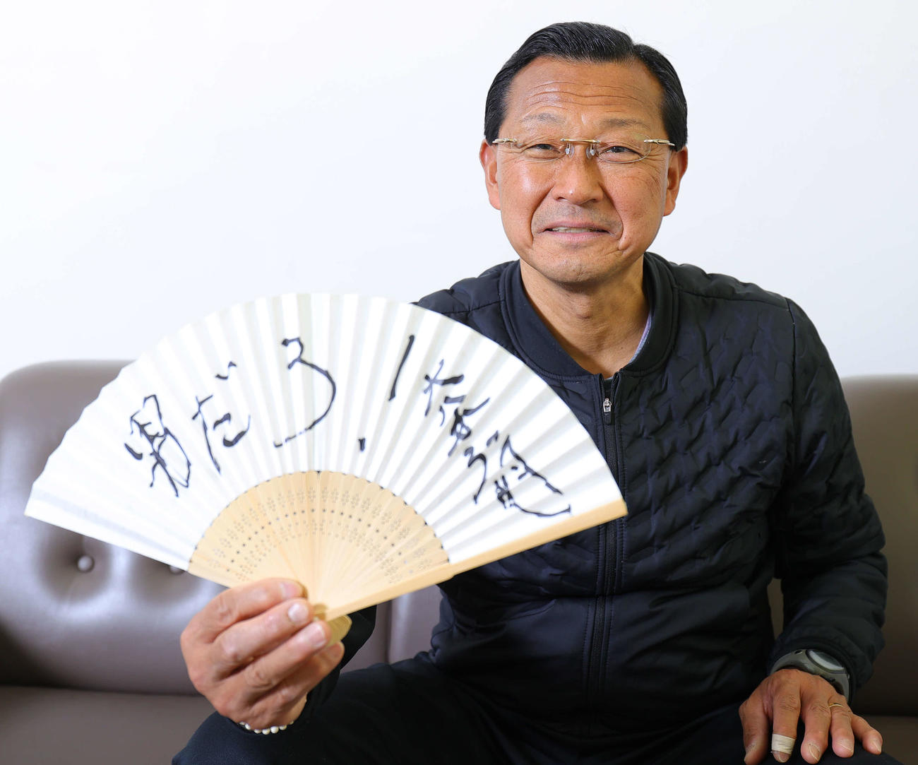 「男だろ！」と記した扇子を広げる駒大・大八木監督（2022年12月）