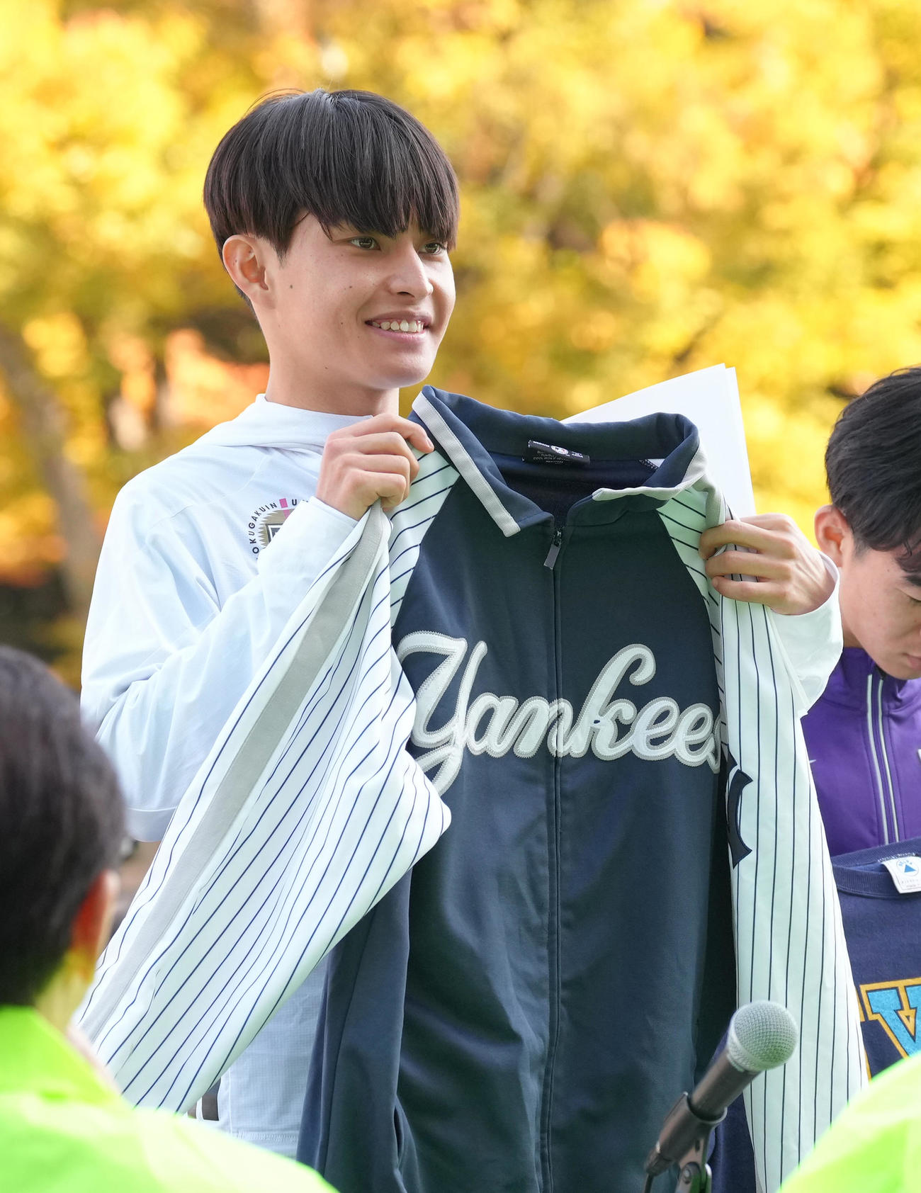 上尾シティハーフマラソンで優勝した国学院大・青木は「ユナイテッド航空NYCハーフマラソン」の出場権を獲得し、記念品のヤンキースのジャンパーを受け取り笑顔（撮影・足立雅史）
