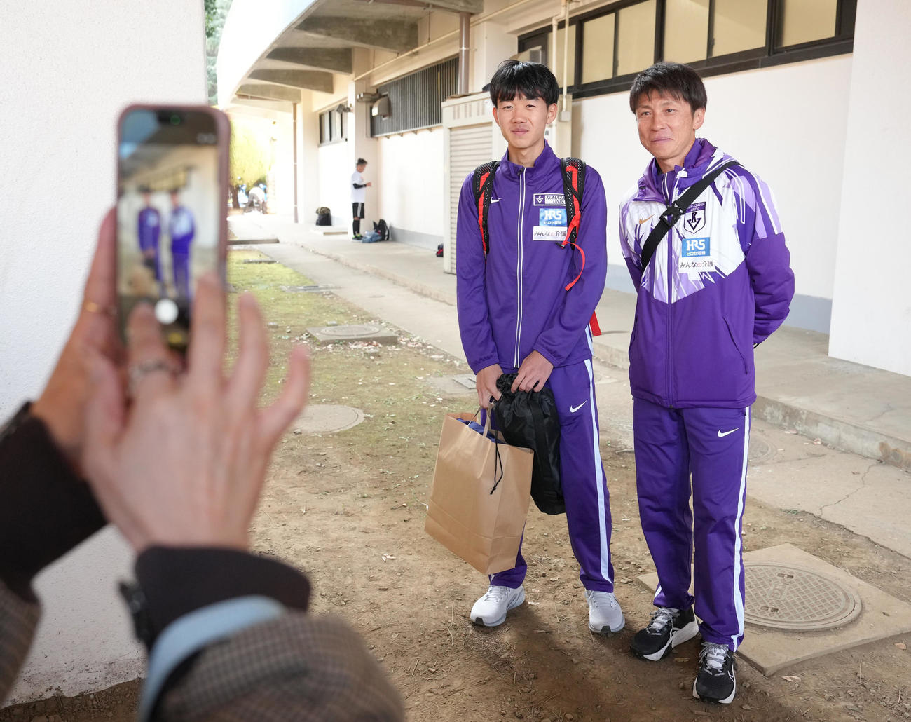 上尾シティハーフマラソン2位の駒大・桑田（左）は藤田監督と記念撮影に応じる（撮影・足立雅史）