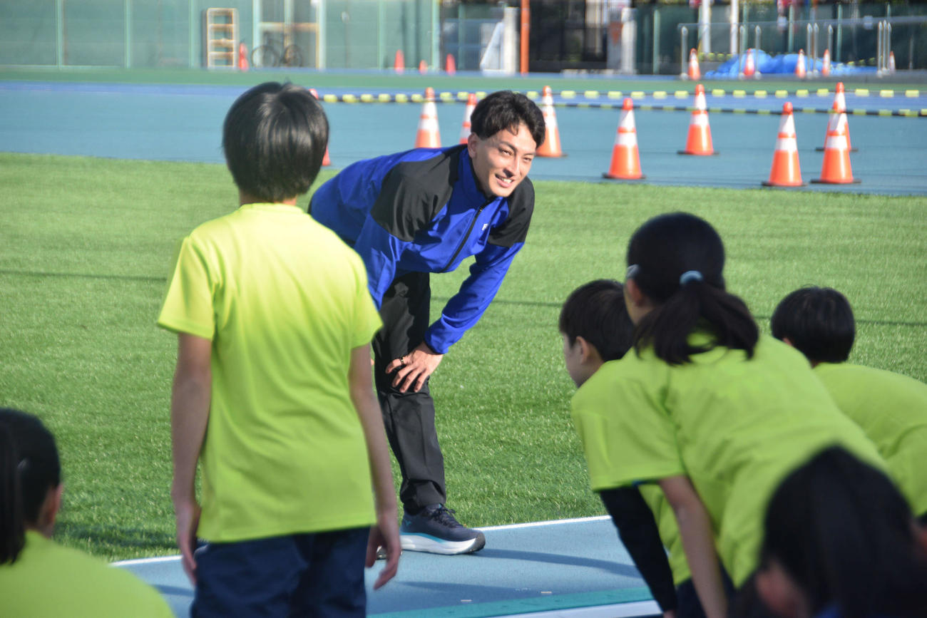 参加した子どもたちと準備体操をする橋岡（撮影・泉光太郎）