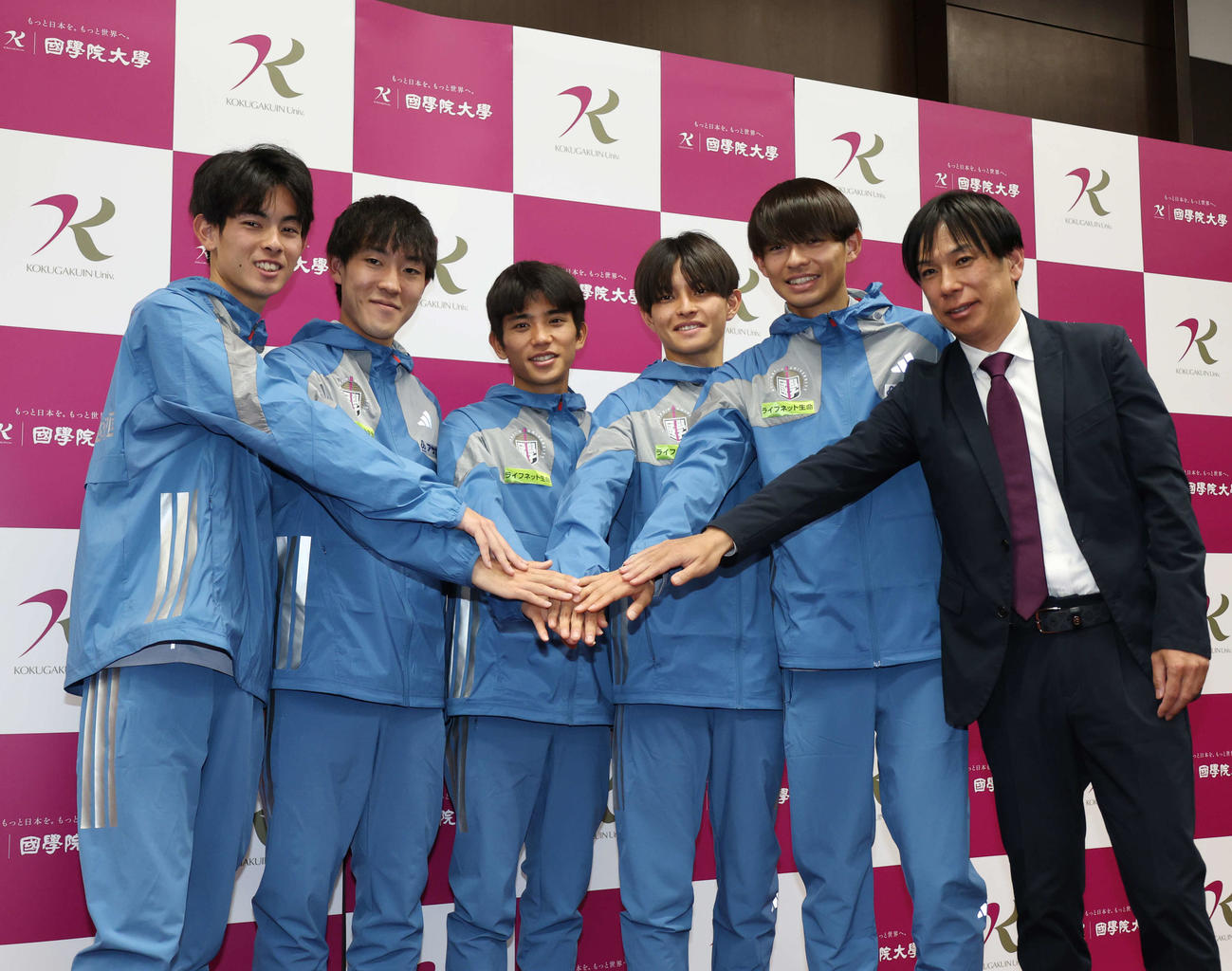 取材会のフォトセッションで手を重ねる国学院大の選手達。左から野中、高山、上原、青木、辻原、前田監督（撮影・増田悦実）