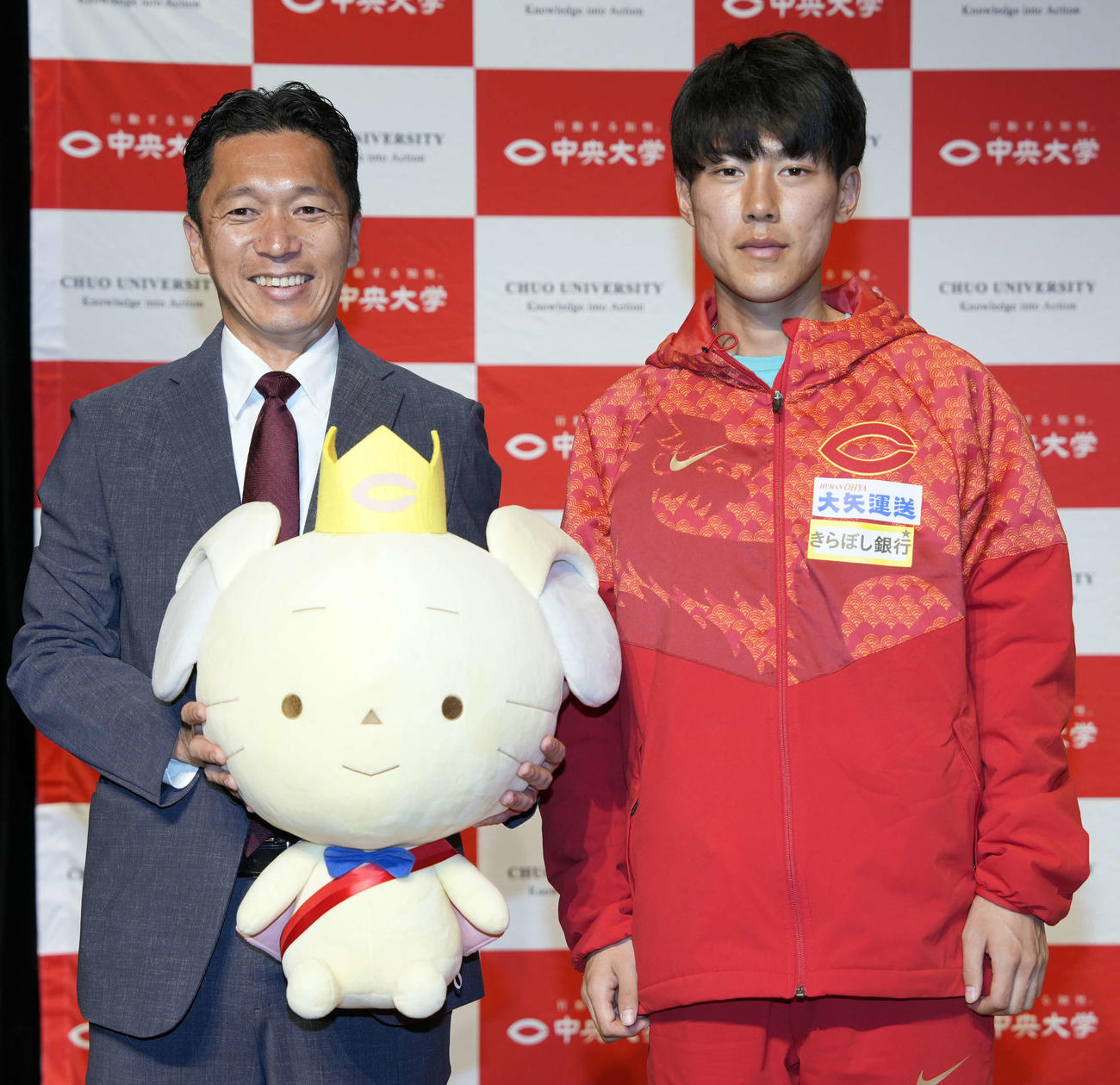 写真に納まる藤原正和監督（左）と吉居（撮影・小島史椰）