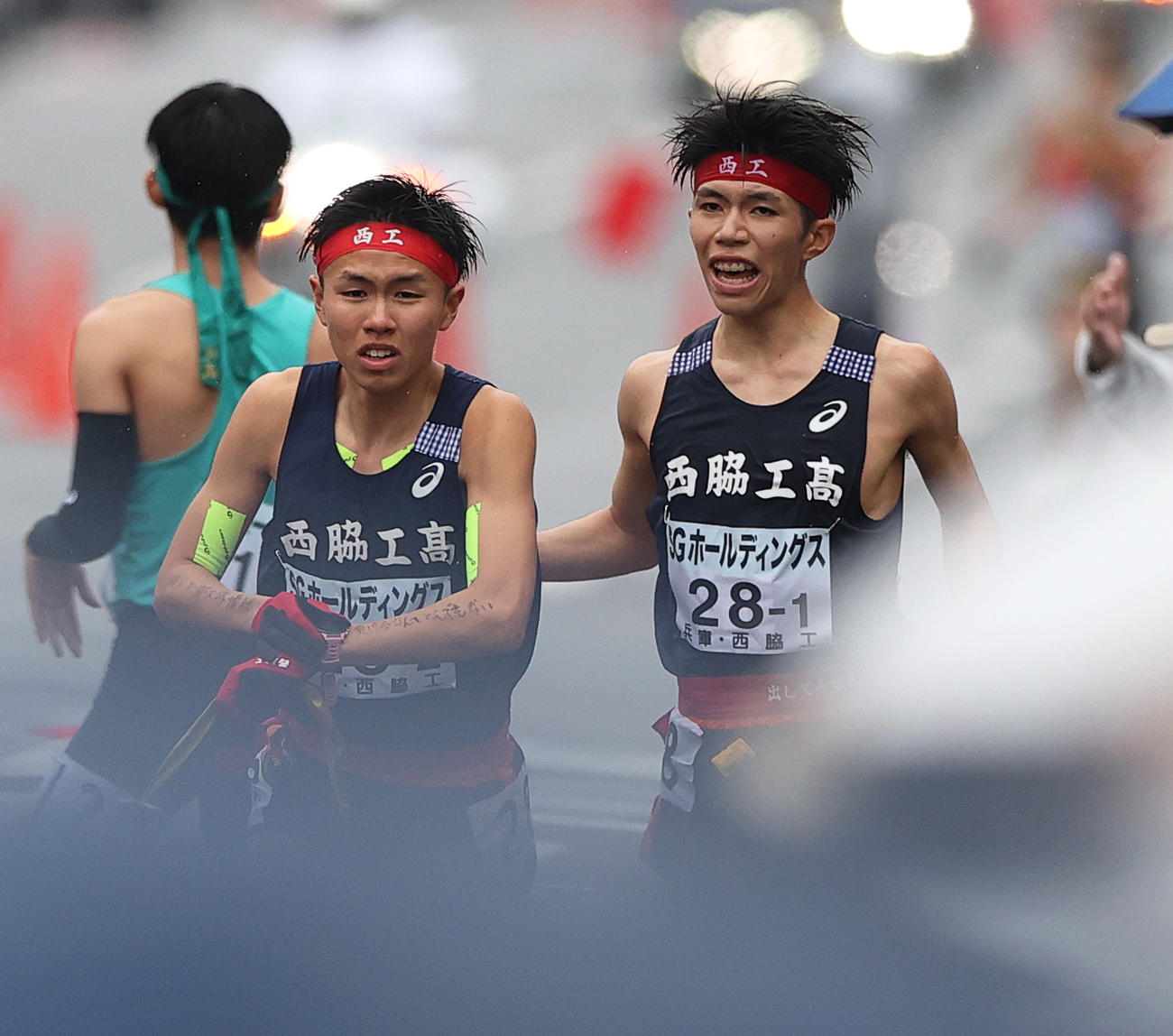 西脇工1区の新妻（右）は2区の岩崎にタスキをつなぐ（撮影・上山淳一）