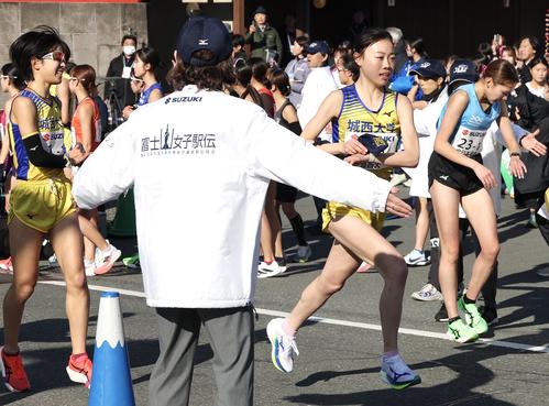 城西大1区兼子心晴（左）からたすきを受け走り出す2区本間（撮影・宮地輝）