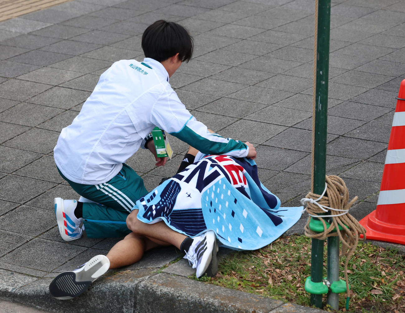 鶴見中継所でタスキリレーをし、倒れ込む青学大・小河原（撮影・増田悦実）