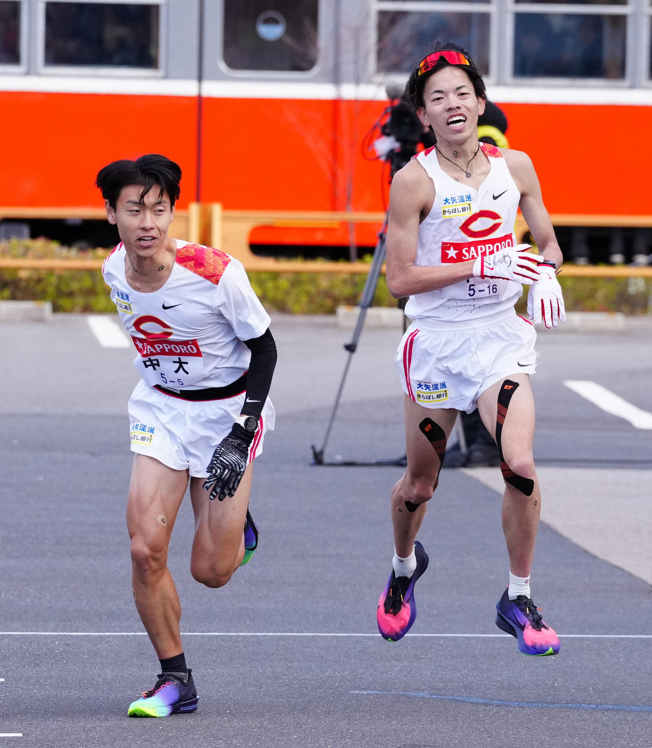 小田原中継所1位で5区柴田（左）にたすきを渡す中大4区岡田（撮影・鈴木みどり）