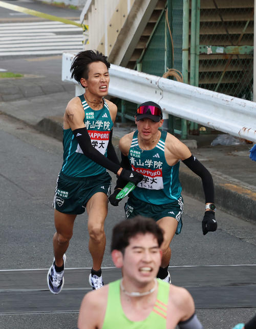 鶴見中継所で青学大・飯田（右）にタスキリレーをする小河原（撮影・増田悦実）