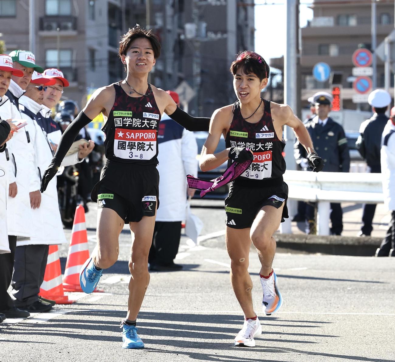 戸塚中継所で国学院大8区飯国（左）は9区野田にタスキをつなぐ（撮影・宮地輝）