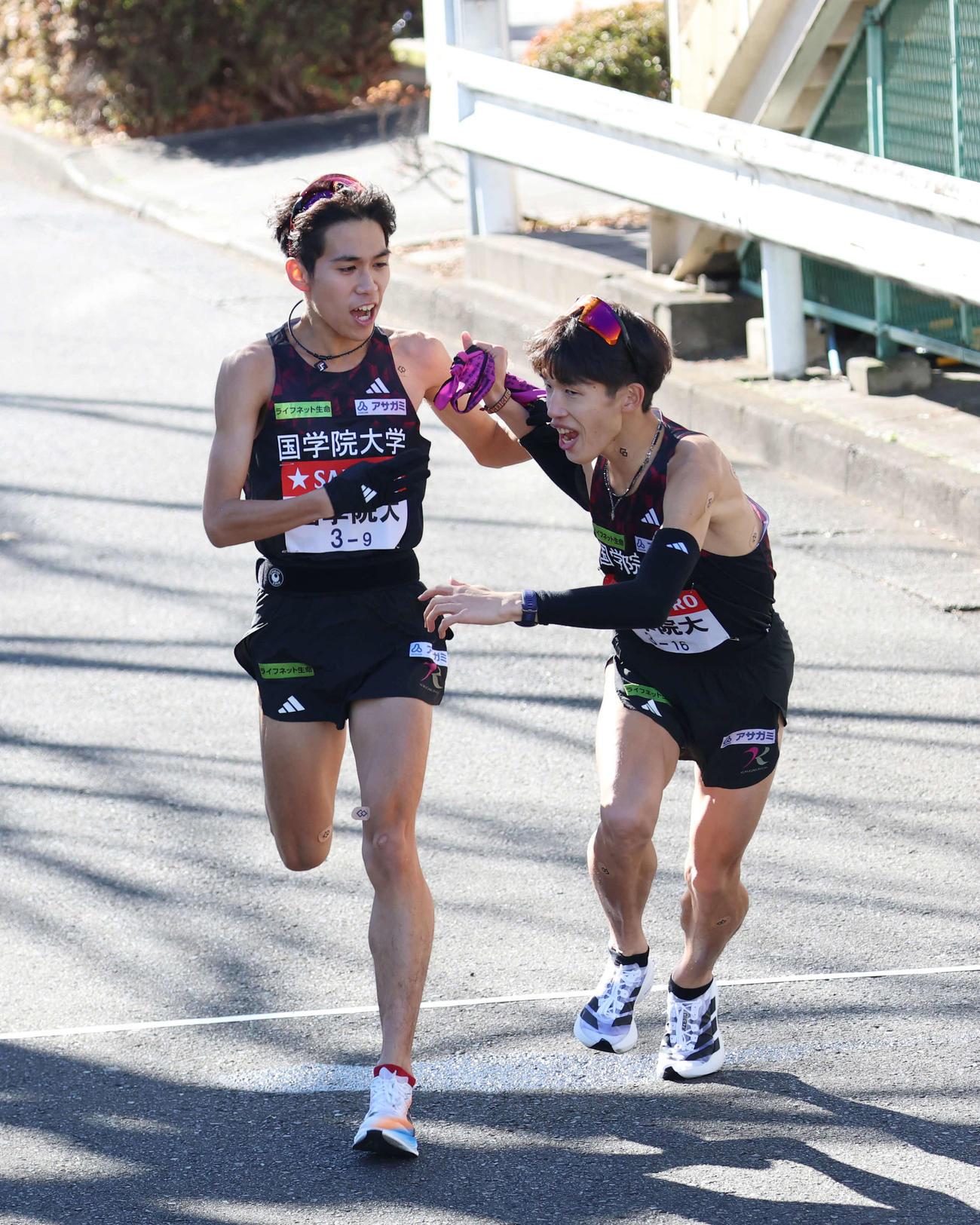 鶴見中継所で10区尾熊（右）にタスキリレーをする国学院大9区野田（撮影・増田悦実）