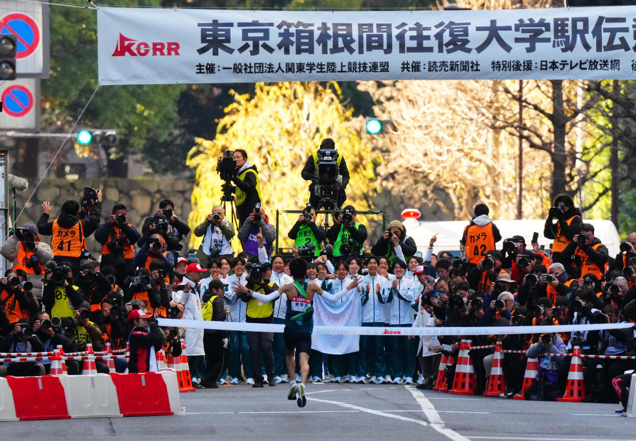 箱根駅伝　往路　1位でゴールする10区折田（手前）を出迎える原監督ら青学大の選手たち（撮影・垰建太）