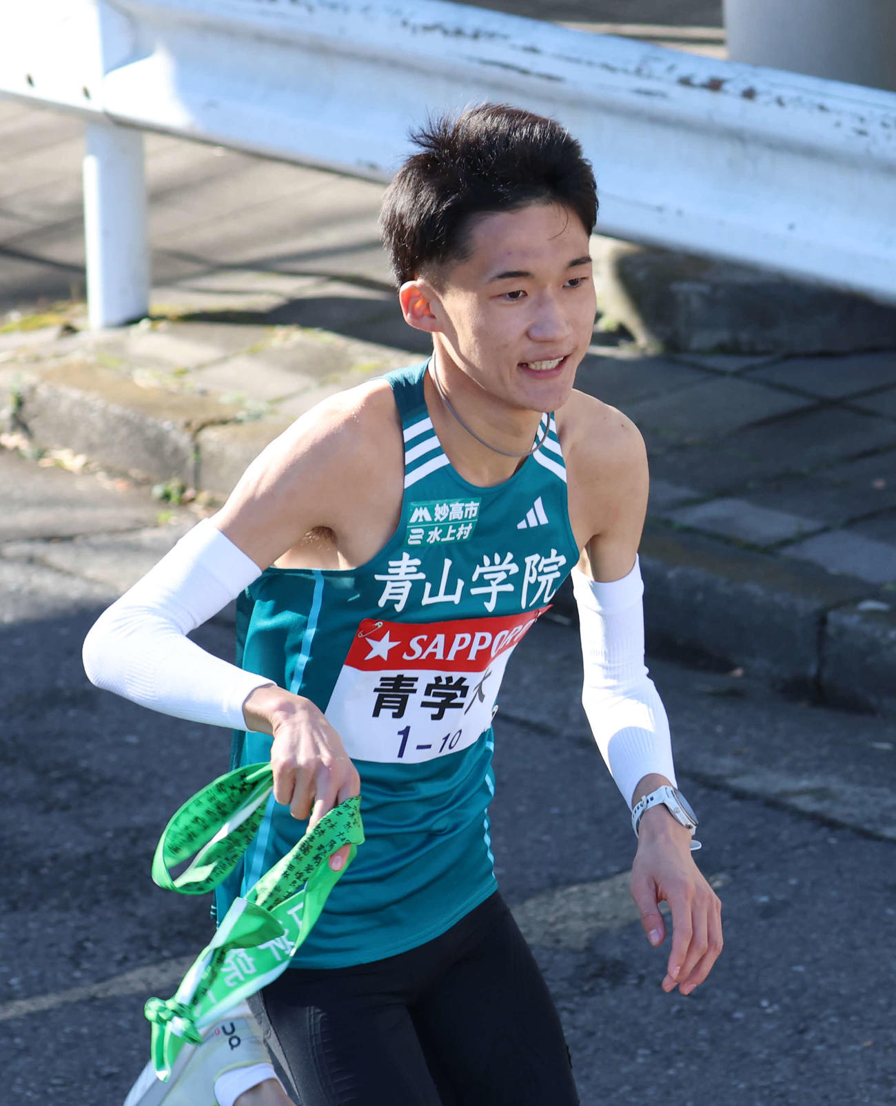 鶴見中継所でタスキを受け取り走り出す青山学院大10区折田（撮影・増田悦実）