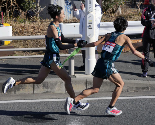 平塚中継所に向かう青学大7区佐藤愛（左）は塩出にタスキをつなぐ（撮影・小島史椰）