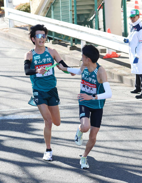 鶴見中継所で10区折田（右）にタスキリレーをする青学大9区佐藤（撮影・増田悦実）