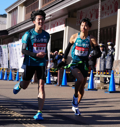 小田原中継所で7区佐藤（右）にたすきを渡す青学大6区石川（撮影・鈴木みどり）