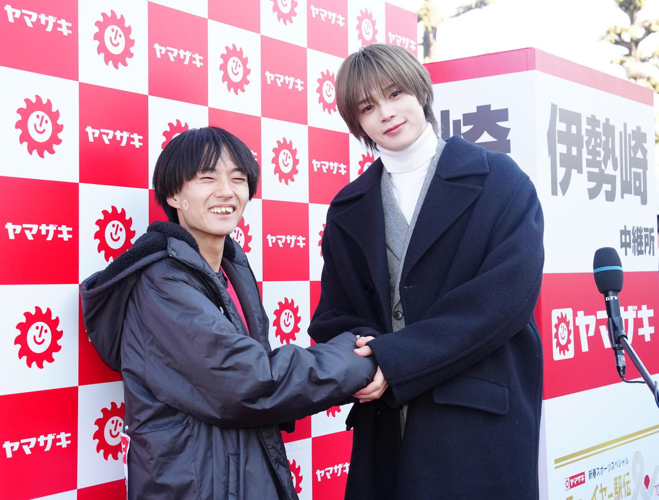 ニューイヤー駅伝の2区で区間賞を獲得し、TBS記念大会サポーターを務める＆TEAMのK（右）と握手を交わすサンベルクスの吉田（撮影・江口和貴）