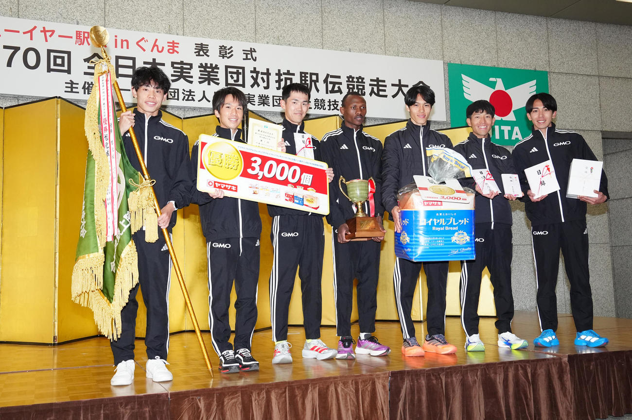 ニューイヤー駅伝で優勝し表彰式で写真に納まるGMOインターネットグループの選手たち。左から2区今江、1区吉田、3区鈴木、4区テモイ、5区太田、6区嶋津、7区鶴川（撮影・江口和貴）