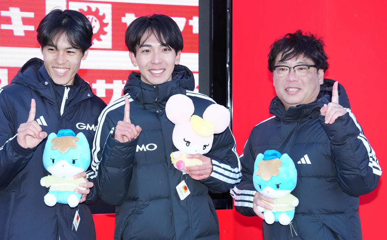 ニューイヤー駅伝で優勝し写真に納まるGMOインターネットグループの選手たち。左から5区太田、7区鶴川、伊藤監督（撮影・江口和貴）