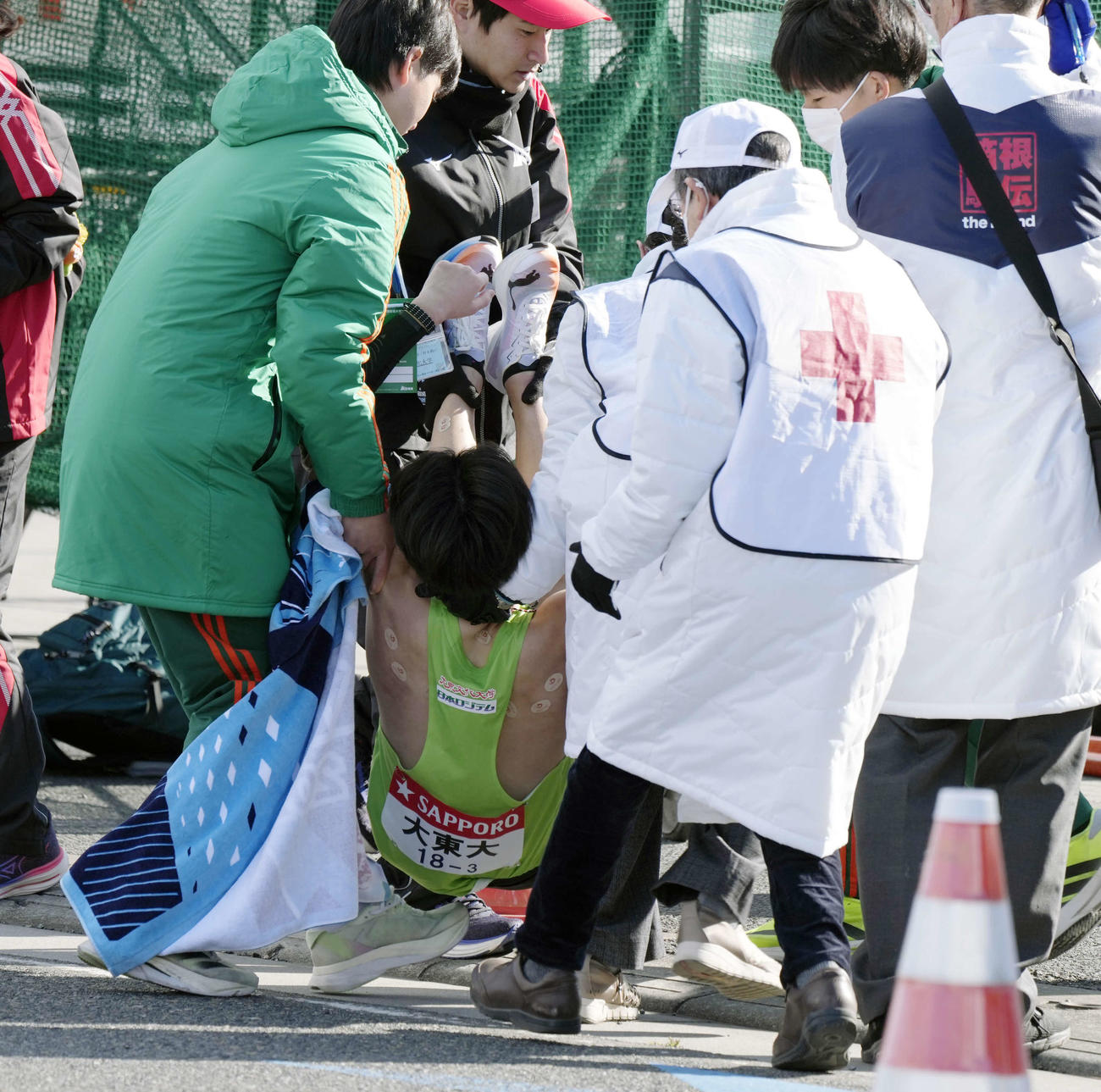平塚中継所でたすきをつないだ後、倒れ込み運ばれる大東大3区菅崎（撮影・小島史椰）
