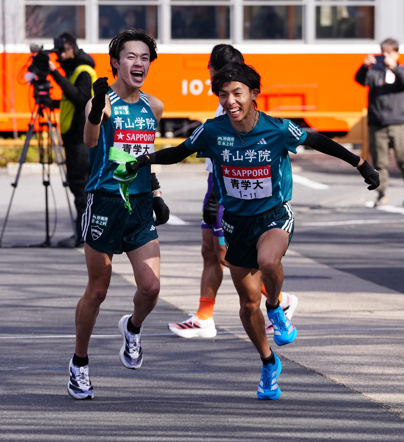 小田原中継所で5区黒田（右）にたすきを渡す青学大4区平松（撮影・鈴木みどり）