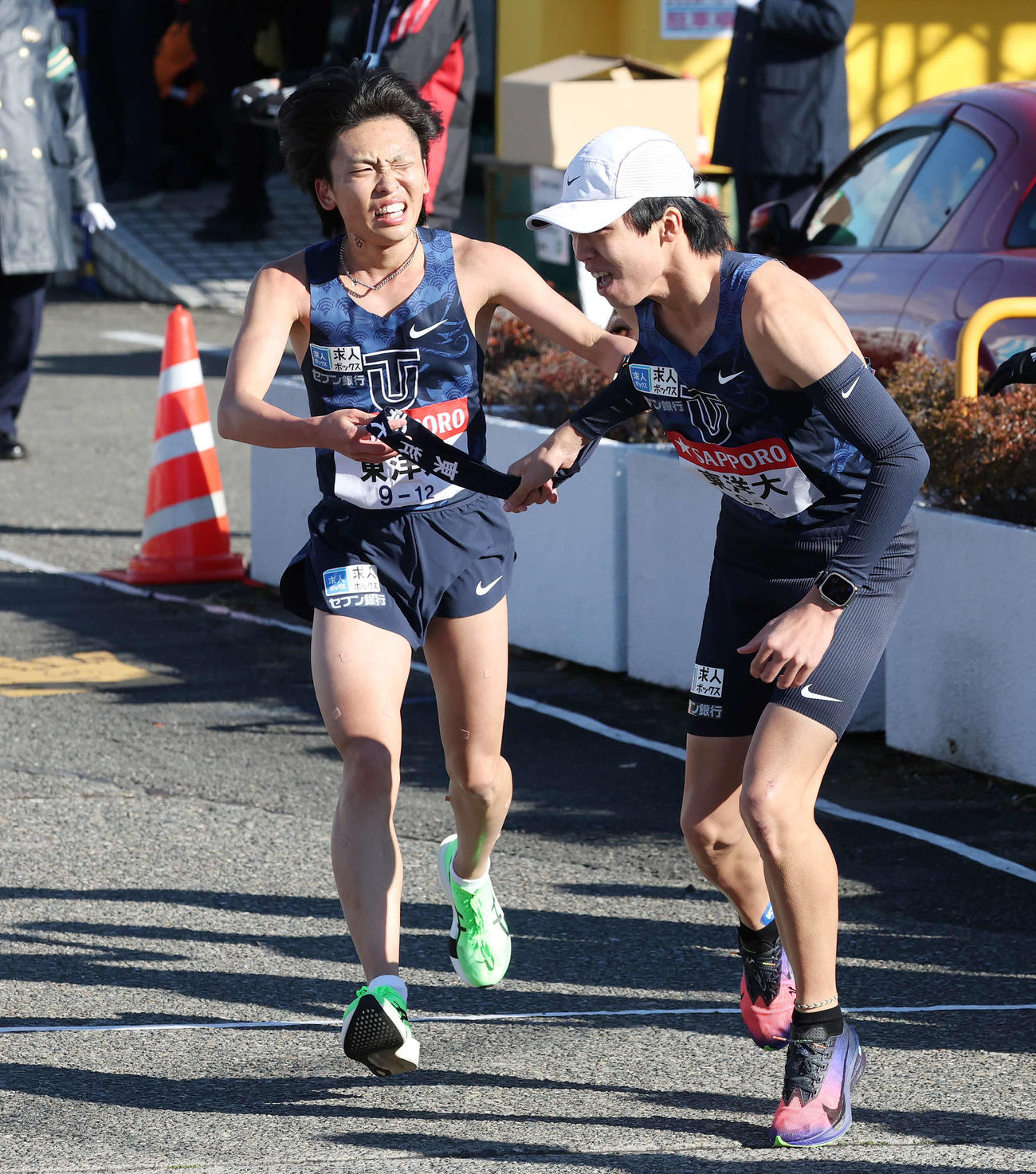 戸塚中継所で東洋大2区西村（左）は3区迎にタスキをつなぐ（撮影・宮地輝）