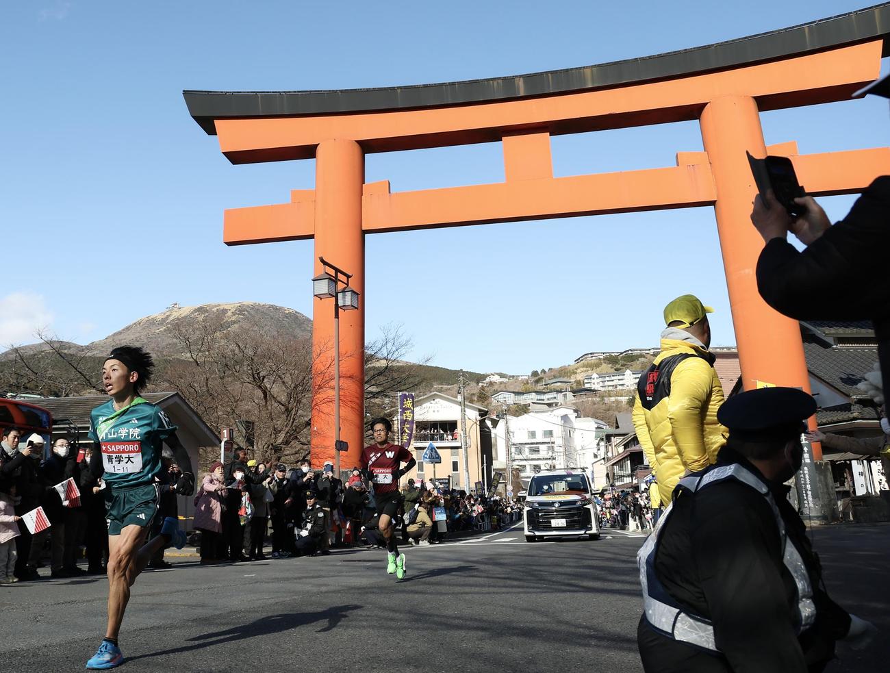 箱根神社鳥居前を通過する青学大5区黒田朝（左）（撮影・河田真司）