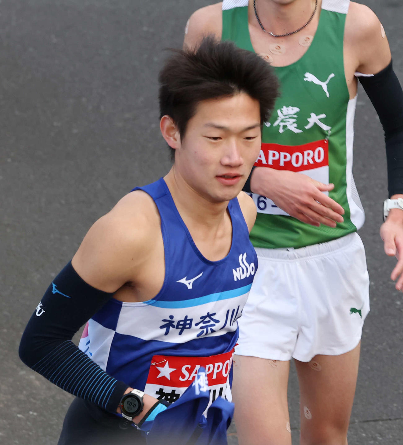 鶴見中継所でタスキを受け取り走り出す神大・宮本（撮影・増田悦実）