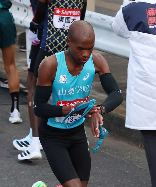 鶴見中継所でタスキを受け取り走り出す山梨学院大・キピエゴ（撮影・増田悦実）