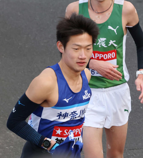 鶴見中継所でタスキを受け取り走り出す神大・宮本（撮影・増田悦実）