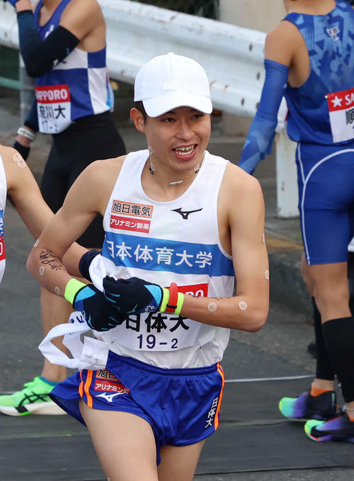 鶴見中継所でタスキを受け取り走り出す日体大・田島（撮影・増田悦実）