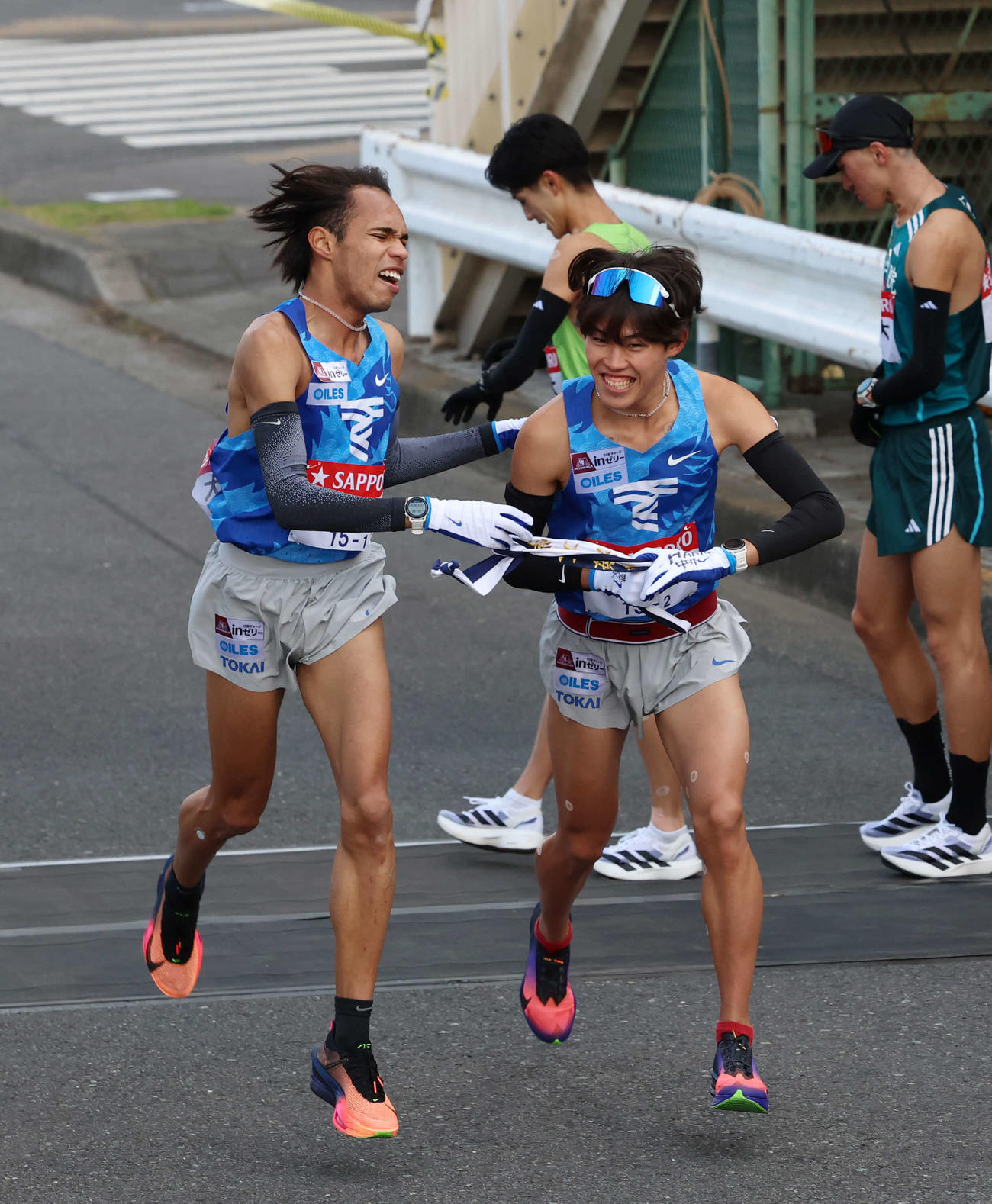 鶴見中継所で東海大・花岡（右）にタスキリレーをする兵藤（撮影・増田悦実）