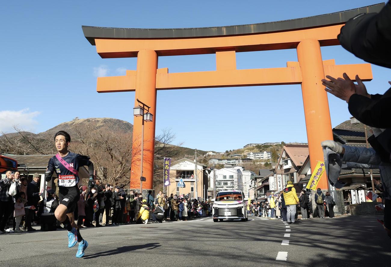 箱根神社鳥居前を通過する日大5区鈴木（撮影・河田真司）