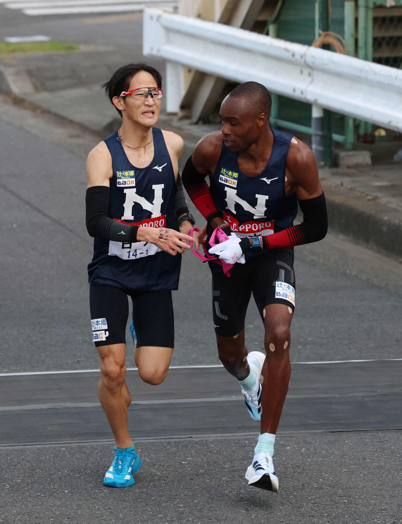 鶴見中継所で日大・キップケメイ（右）にタスキリレーをする山口（撮影・増田悦実）