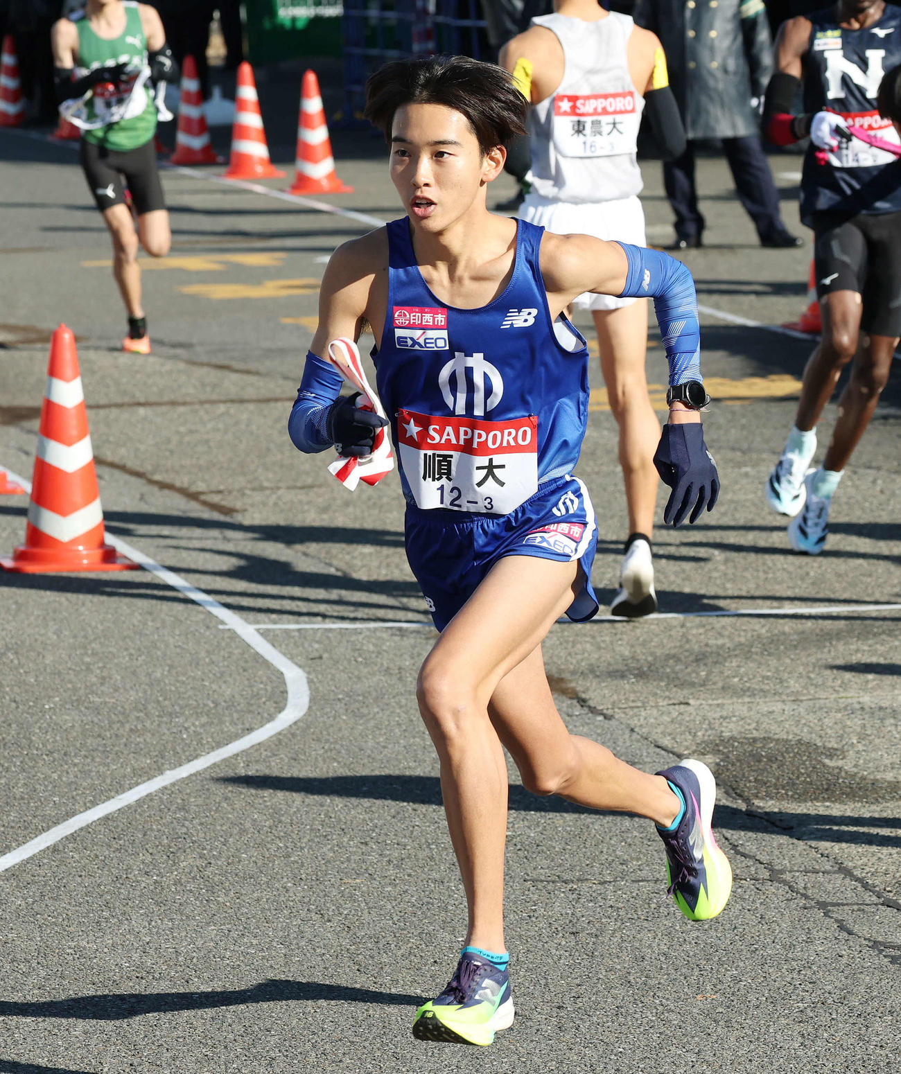 戸塚中継所でタスキを受け駆け出す順大3区井上（撮影・宮地輝）